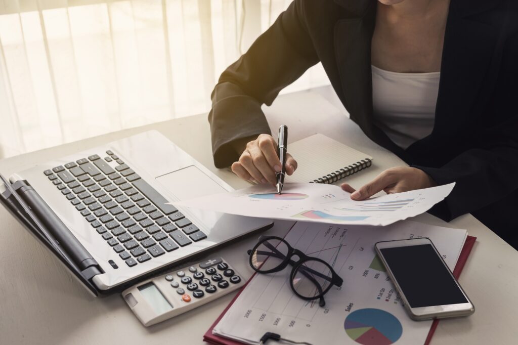 Businesswoman analyzing financial report with laptop