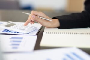 Close-up of businesswoman calculating accounting with calculator.