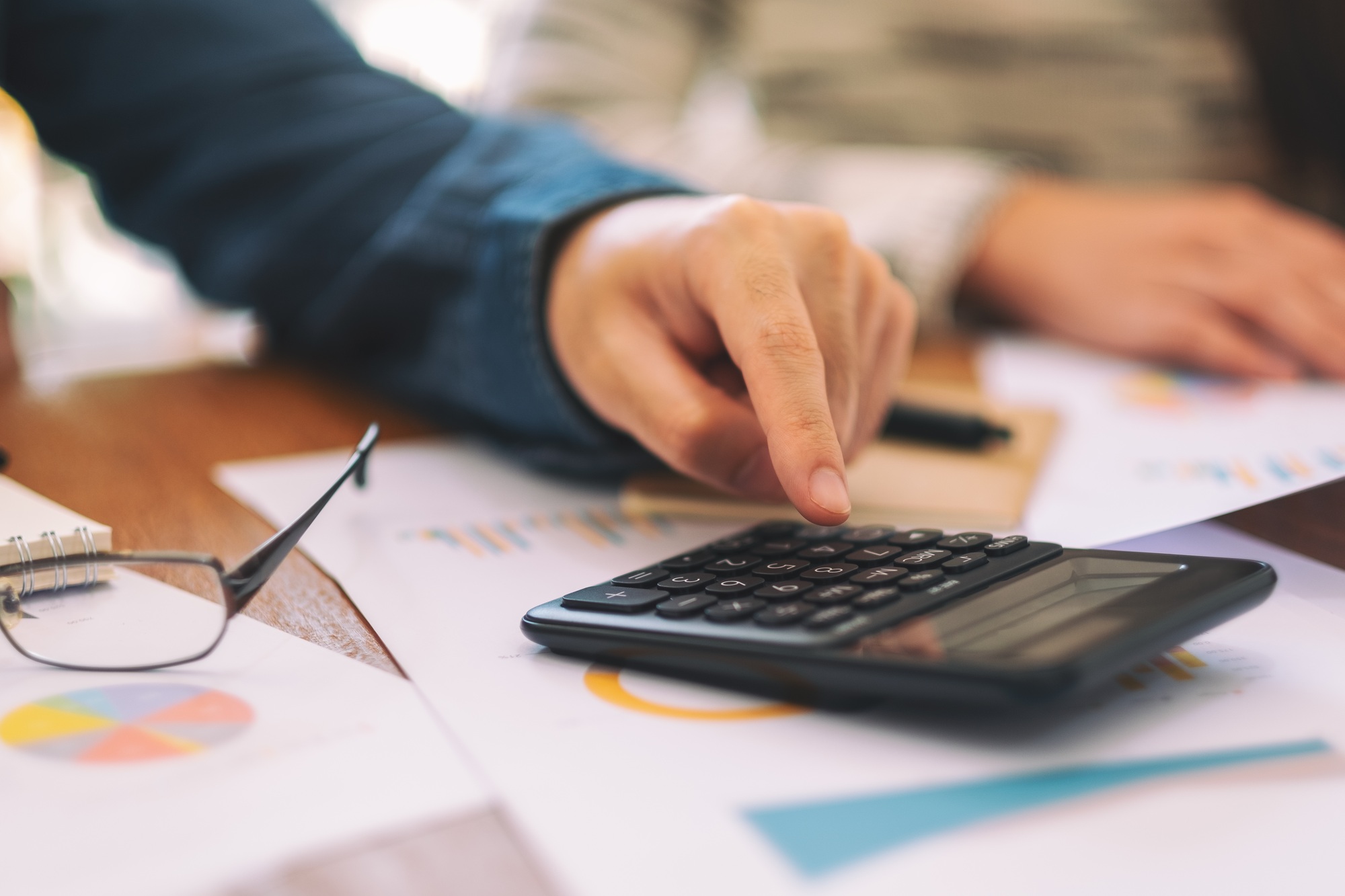 Closeup image of a businessman using calculator in a business meeting