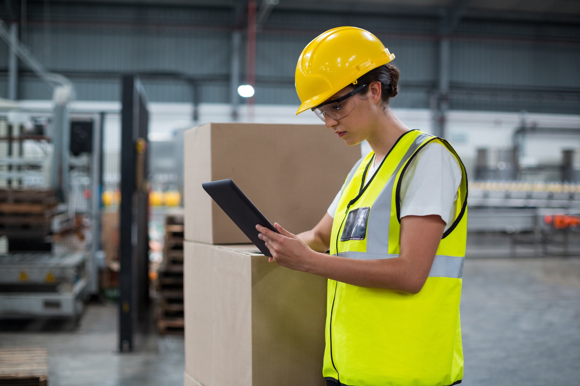 Female factory worker using a digital tablet in factory